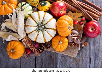 Pumpkins, nuts, indian corn and apples on a rustic table overhead corner frame with empty space - Powered by Shutterstock