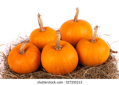 Pumpkins with straw on hay stack isolated on white