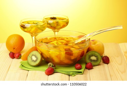 Punch In Bowl And Glasses With Fruits, On Wooden Table, On Yellow Background