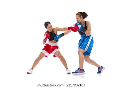 Punch. Dynamic portrait of two female professional boxers boxing isolated on white studio background. Two muscular athletes in boxing gloves sparring. Sport, competition, show, power, action concept. - Powered by Shutterstock