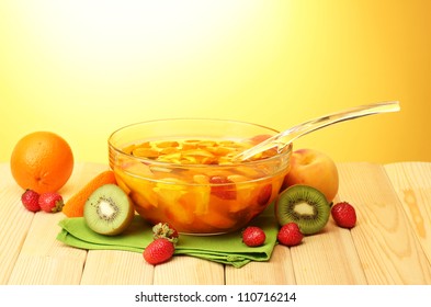 Punch In Glass Bowl With Fruits, On Wooden Table, On Yellow Background