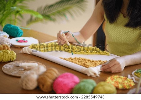 Punch needle. Asian Woman making handmade Hobby knitting in studio workshop. designer workplace Handmade craft project DIY embroidery concept