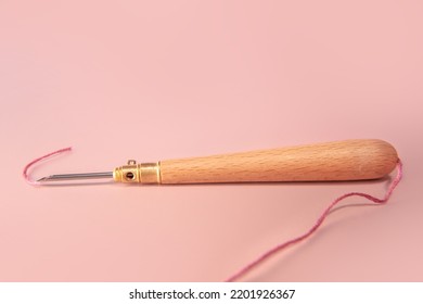 Punch A Needle  With Embroidery Threads, Floss Threads On A Pink Background