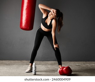 Punching bag, tired boxer or woman on break in boxing training, exercise or workout in gym studio. Sweating, sports athlete or exhausted girl with fatigue, fitness or water bottle on grey background - Powered by Shutterstock