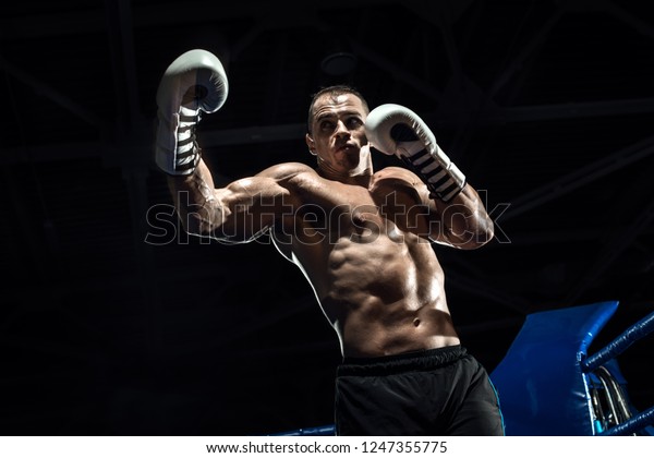 ボクシングリングの上にパンチボクサー 黒い背景 横向き写真 の写真素材 今すぐ編集