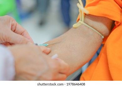 Puncture Of A Vein Through The Skin In Order To Withdraw Blood For Analysis.the Specialist Uses A Syringe To Venipuncture From Patient's Arm. Selective Focus