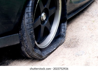 Punctured wheel of a modern car on the road. Car tire puncture. - Shutterstock ID 2023752926