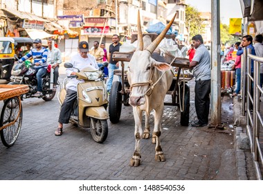 Pune, Maharashtra / India - April 1, 2018: Busy City Street Showing Old Vs New Transportation Side By Side - Ox Drawn Bullock Cart And Motorcycles.