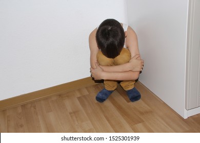 Punished For A Bad Deed, The Boy Sits In The Corner, Hiding His Face In His Knees, Educational Concept