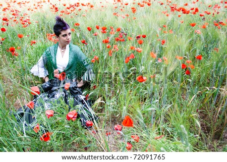 punk girl dressed in folk in a field of poppies