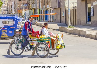 PUNO, PERU, MAY 5, 2014: Pedicab transporst local woman in traditional attire in city center 