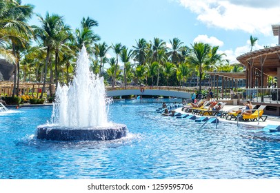 Punta Cana, Dominican Republic - October 26, 2018: People Relax In The Swimming Pool Among Palm Trees In The Resort Of Punta Cana.