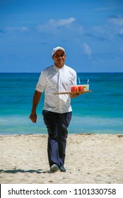 Punta Cana, Dominican Republic - September 16, 2014: Waiter carrying cold drinks on the beach