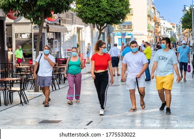 Punta Umbria, Huelva, Spain - July 10, 2020: People Walking By Street Calle Ancha In Punta Umbria Village Wearing Protective Mask Due To Covid-19. New Normal In Spain