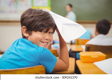 Pupil about to throw paper airplane at the elementary school - Powered by Shutterstock