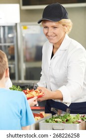 Pupil In School Cafeteria Being Served Lunch By Dinner Lady