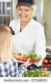 Pupil In School Cafeteria Being Served Lunch By Dinner Lady