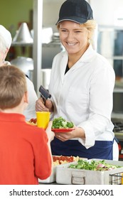 Pupil In School Cafeteria Being Served Lunch By Dinner Lady