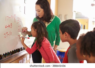 Pupil writing on the board at elementary school maths class - Powered by Shutterstock