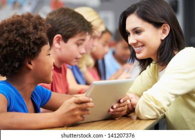 Pupils In Class Using Digital Tablet With Teacher
