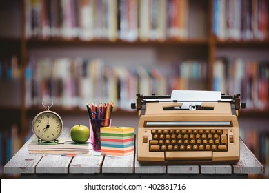 Pupils Desk With Books And Supplies Against Library Shelf