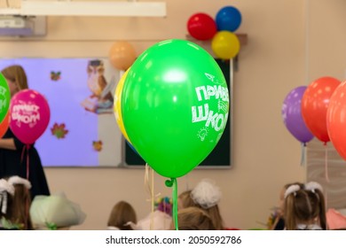 Pupils First Graders And A Teacher In A School Class In A Lesson On September 1st With Bright Colorful Balloons. The Inscription Is Hello School. Selective Focus