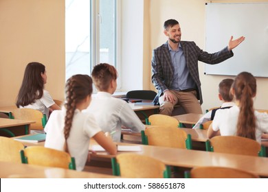Pupils listening teacher in classroom - Shutterstock ID 588651878