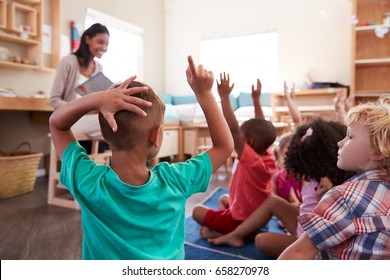 Pupils At Montessori School Raising Hands To Answer Question - Powered by Shutterstock