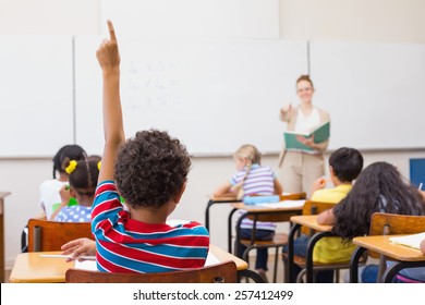 Pupils Raising Hand In Classroom At The Elementary School