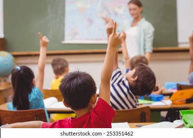 Schüler, die im Unterricht in Geografie im Unterricht in der Grundschule die Hand heben