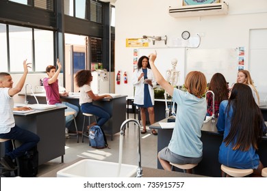 Pupils Raising Hands In A High School Science Lesson