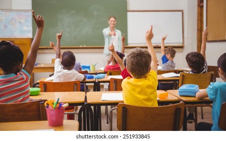Pupils raising their hands during class at the elementary school - Shutterstock ID 251933845