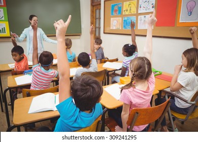 Schüler, die sich während des Unterrichts in der Grundschule die Hände heben