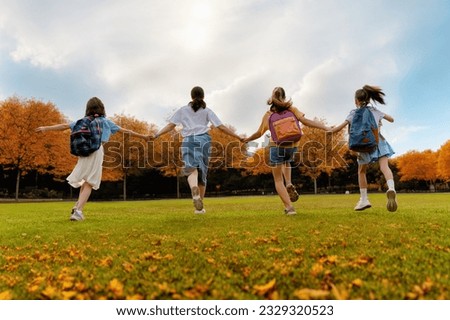 Pupils of the school. Girls with backpacks outdoors. Teens and their mother or teacher. Beginning of lessons. First day of fall.
