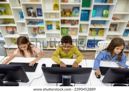 Pupils studying on computers in school library.