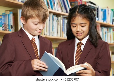 Pupils Wearing School Uniform Reading Book In Library