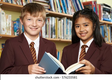 Pupils Wearing School Uniform Reading Book In Library