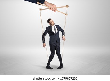 Puppet businessman in an empty room leaded by a huge hand