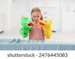 Puppet theatre. Cute girl performing show with toys at home