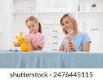 Puppet theatre. Mother and daughter performing show at home