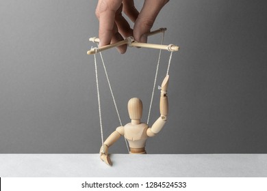 Puppeteer manipulates the doll. Voting unfair. The man raised his hand gives his fake voice