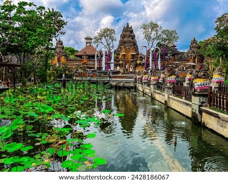 Pura Taman Saraswati Temple in Ubud. Beautiful Asian landscape, lotus flower pond water garden, ancient red Hindu temple, blue sky
