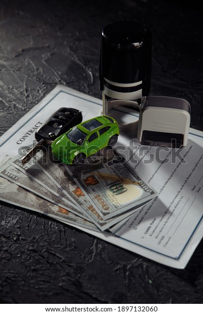 Purchase contract for a car with stamps, keys and\
toy car. Vertical\
image