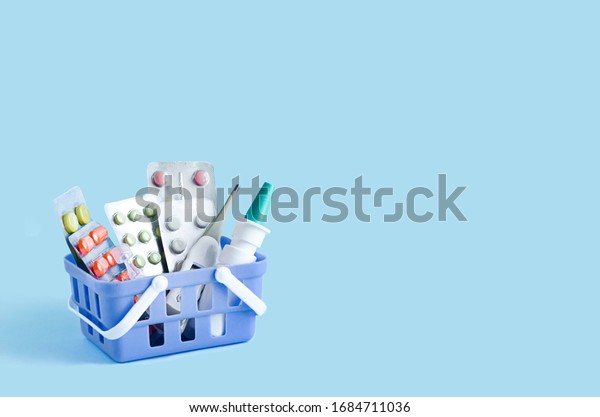 purchase,
delivery of medicines to your home. home first aid kit for colds,
illnesses, viruses, epidemics. online purchase of medicines. drugs
in basket on blue background, copy
space