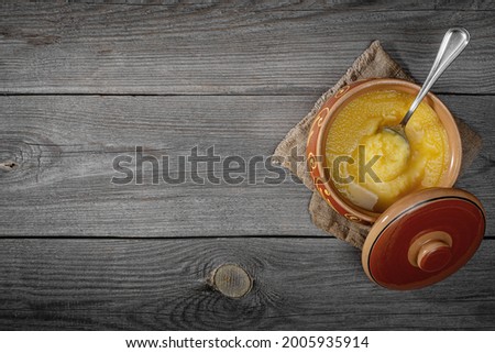 
Pure OR Desi Ghee also known as clarified liquid butter. Pure OR Desi Ghee in ceramic bowls on an old wooden table. Top view.