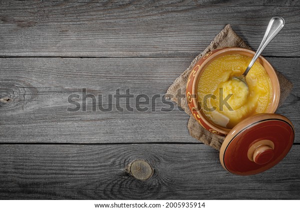 \
Pure OR Desi Ghee also known as clarified liquid\
butter. Pure OR Desi Ghee in ceramic bowls on an old wooden table.\
Top view.