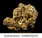 Pure gold from the mine on black background. Closeup of gold nugget. Finance and business concept.