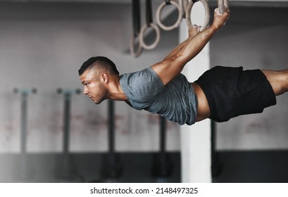 Pure power. Cropped shot of a young man working out on the gymnastics rings. - Powered by Shutterstock