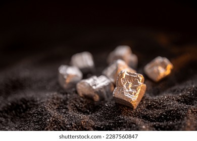 Pure silver or platinum or rare earth from the mine that was placed on the black sand - Shutterstock ID 2287560847