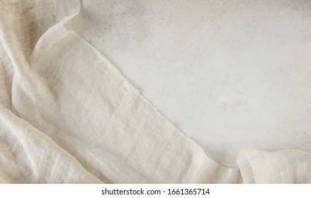 Pure washed linen cloth on light grunge stone background. Natural washed linen fabric on stone tile surface with copy space.
